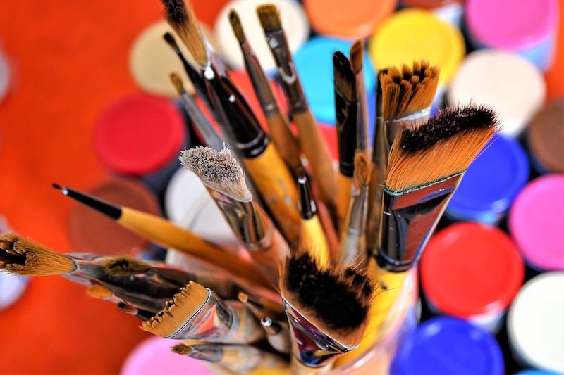 Brushes in the midst of acrylic paint bottles