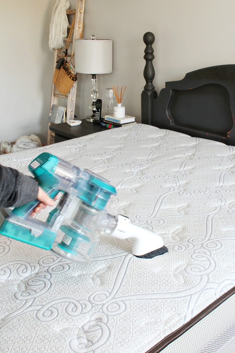 Tineco handheld vacuum used to clean a mattress.